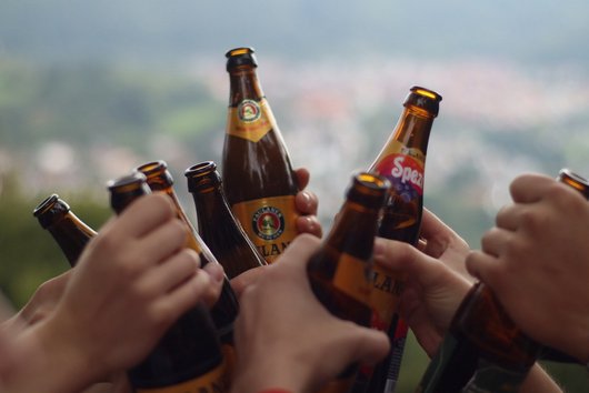 Several people toast with beer and Spezi